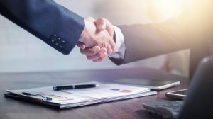 two businessmen shake hands to celebrate a business deal free photo scaled